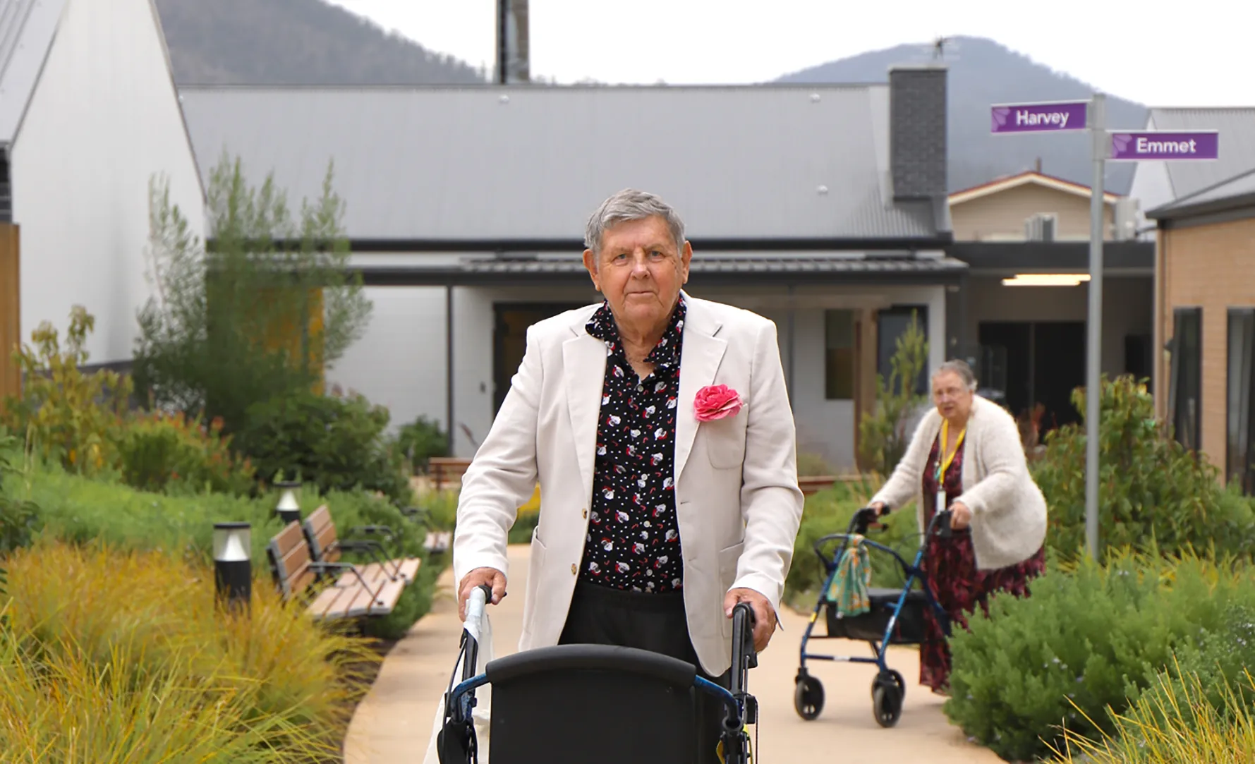 Two residents walking on a path through Korongee Village